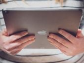 Latest Apple iPad Pro release, held by a woman in a store