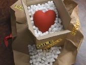 Red heart and packing peanuts in shipping box