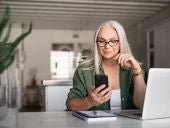 Stylish senior woman messaging with phone