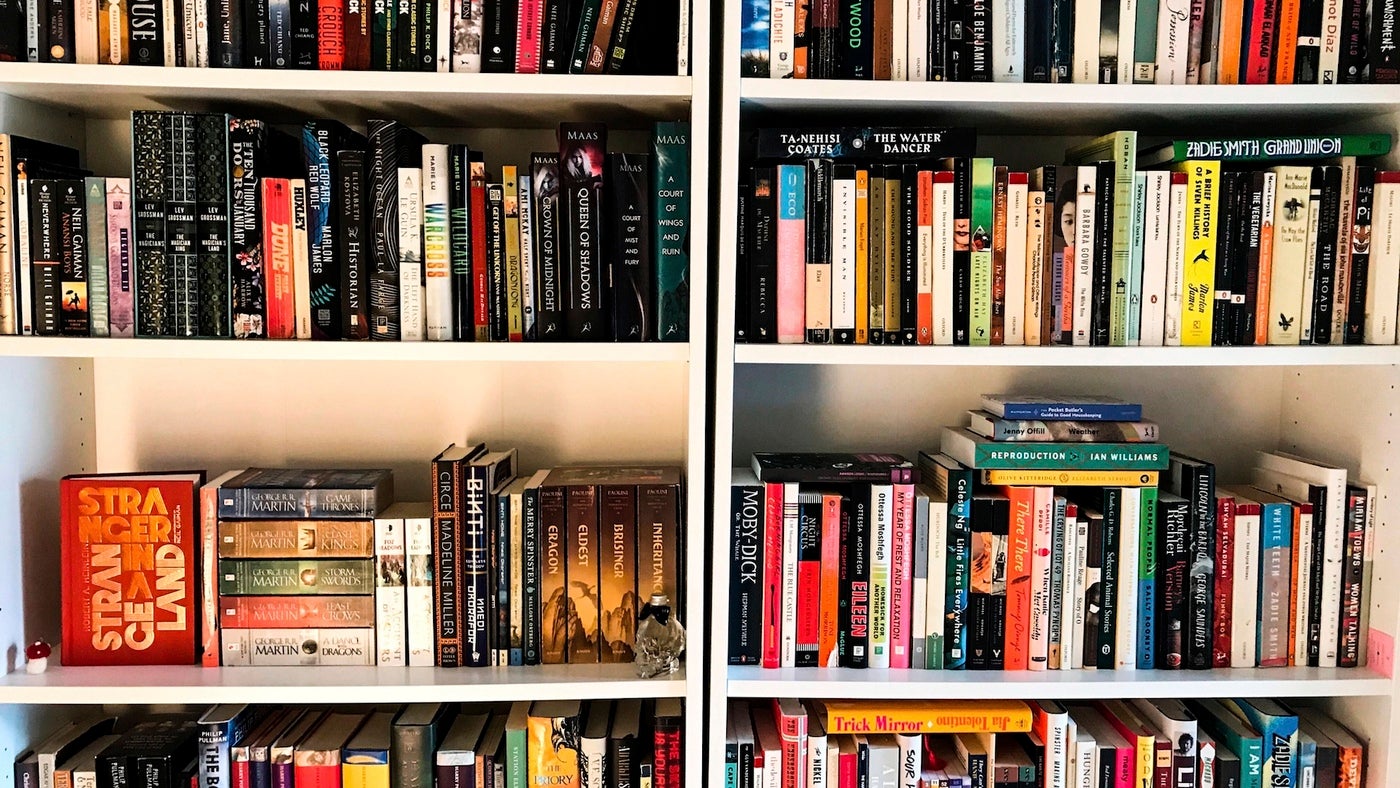 Two white bookshelves packed with colorful books from Penguin Random House.