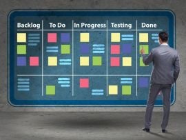 A project manager in front of a kanban board.