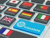 Foreign languages translation concept, online translator, macro view of computer keyboard with national flags of world countries on keys and blue translate button