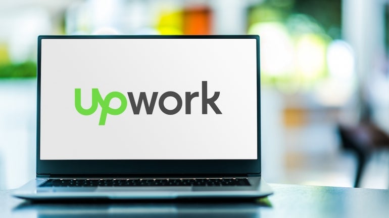 Laptop computer displaying logo of Upwork.