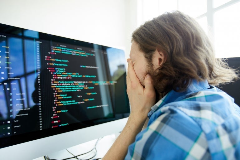 Stressed computer programmer in front of computer