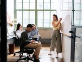 Woman using whiteboard in a small team meeting.