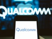 User holds a smartphone displaying Qualcomm's logo