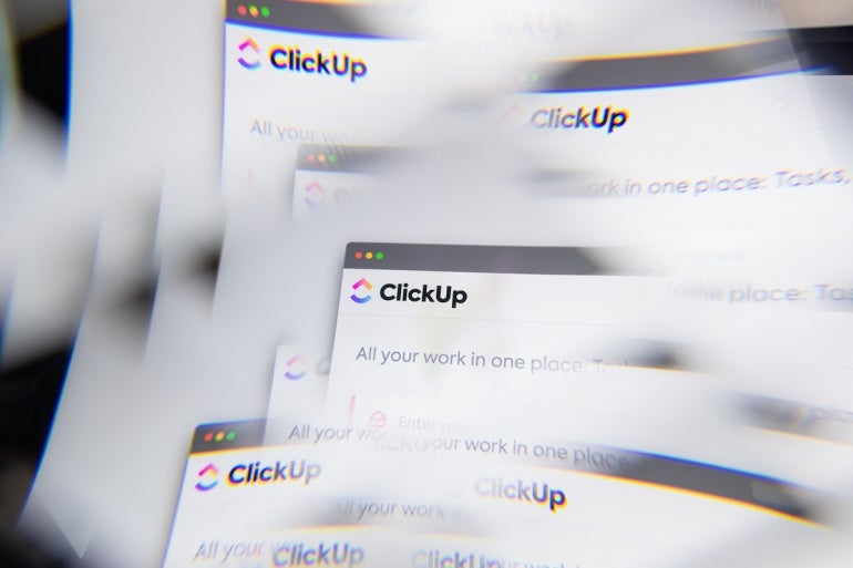 ClickUp logo on laptop screen seen through an optical prism.