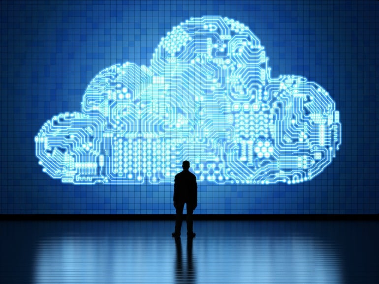 Person looking up at an image representing cloud computing technology.