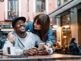 Young man and woman using telephone