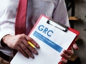 Businessman with GRC Governance risk management and compliance documents.