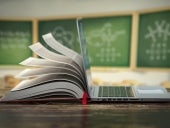 E-learning online education or internet encyclopedia concept. Open laptop and book compilation in a classroom.