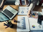 Business person analyzing financial statistics displayed on the laptop screen