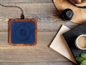 NYTSTND UNO MagSafe wireless charger on a table beside a cup of coffee and journals.