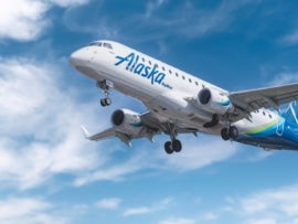 An Alaska Airlines plane flying in the sky.