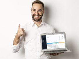 A business man holding a computer with backed up email and giving a thumbs up.