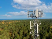 telecommunication tower with antennas for 5g network on forest and blue sky background