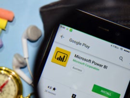 Microsoft Power BI dev app with magnifying on Smartphone screen. Microsoft Power BI is a freeware web browser developed by Microsoft Corporation
