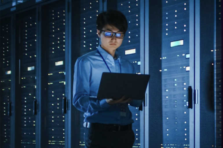 A cybersecurity professional in a server room.