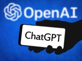 This illustration shows the ChatGPT logo on a phone in front of the OpenAI logo.