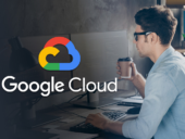 Google Cloud logo hovering over a man working at a computer while drinking from a hot beverage