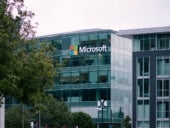 Microsoft logo is prominently displayed on the outside of a multi-story glass building.