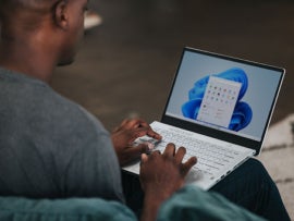 Man working on his laptop with MS Office icons on the screen.
