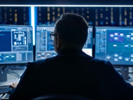 A chief information security officer looking at many screens.