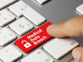 A red Medical Data Breach button on a laptop keyboard.