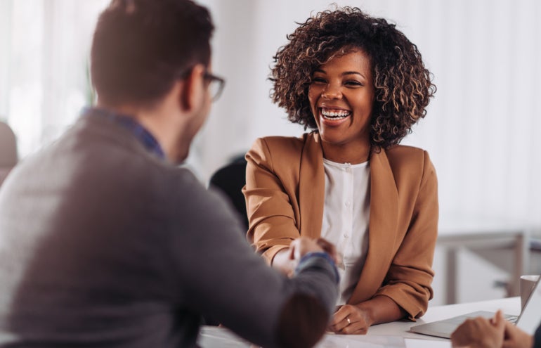 Happy businesswoman shaking hands with colleage after successful meeting.