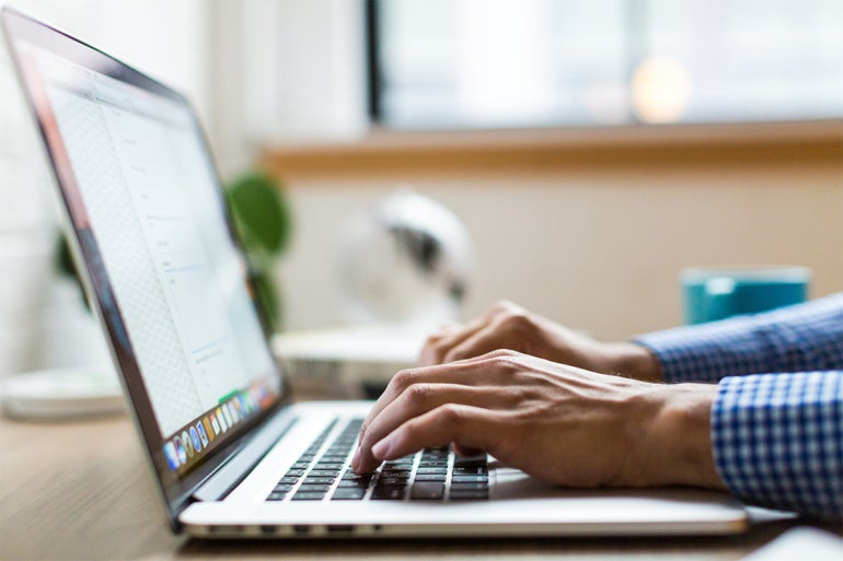 Person typing on a laptop.