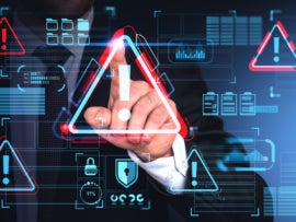 Hand of businessman using malware alert cybersecurity interface with triangular warning icon on touch screen over blue background.