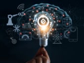 Hand holding light bulb and cog inside and innovation icon network connection on brain background.