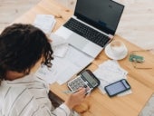 Businesswoman analyzing accounting documents while in front of her laptop.