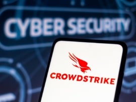 A photo of CrowdStrike Falcon logo in a smartphone with the word Cyber Security at the background.