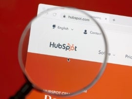 Hubspot website on a computer screen with magnifying glass in front.