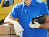 Man with gloves holding a package and a clip folder.