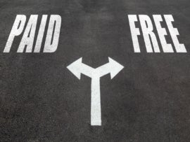 Paid vs free choice concept, two direction arrows on asphalt.