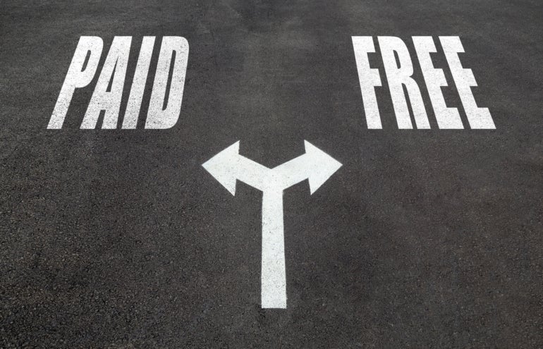 Paid vs free choice concept, two direction arrows on asphalt.