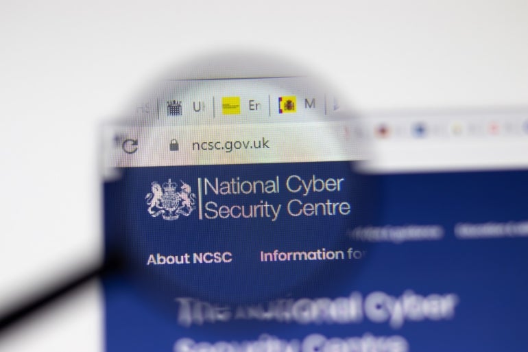 NCSC National Cyber Security Centre website page on display screen with magnifying glass.