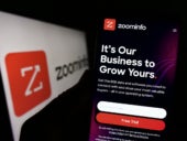 Person holding cellphone with website of US software company ZoomInfo Technologies Inc. on screen with logo.