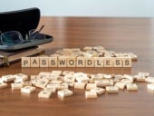 passwordless word or concept represented by wooden letter tiles on a wooden table with glasses and a book