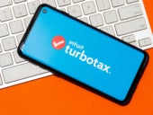 TurboTax application on a smartphone with keyboard in the background.