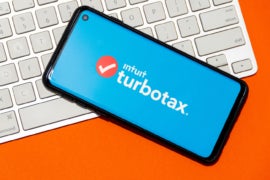 TurboTax application on a smartphone with keyboard in the background.