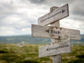 governance risk compliance text on wooden signpost outdoors in landscape scenery.