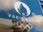 Paris 2024 Olympics logo on glass pane.