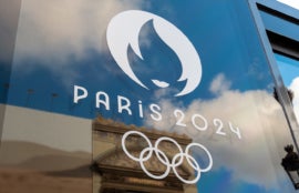 Paris 2024 Olympics logo on glass pane.