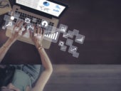 Businesswoman using laptop with virtual data analytics icons.