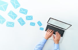 Business man sending and receiving email using laptop on white table.