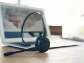 A call center headset set beside a laptop.