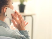 Woman talking by mobile phone at home.